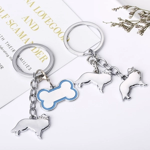 Détail de porte-clés avec breloque chien de berger et os bleu serti de strass