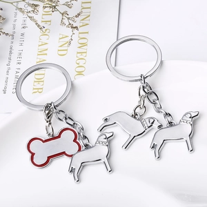 Détail du porte-clés chien et os avec collier étincelant présenté dans un plat blanc en céramique