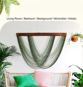 Detail of bohemian woven macrame wall hanging with green fringe and wooden bar