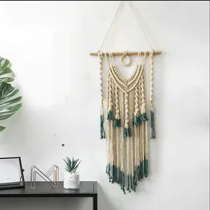 Detail of bohemian macramé wall hanging with cotton fringe and dark green dip-dyed ends