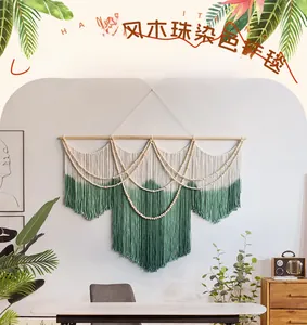 Detail of hand-knitted bohemian wall tapestry with green gradient fringe and wooden beads