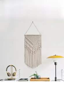 Detail of Nordic bohemian hand-woven wall tapestry with cotton tassels and wooden pole