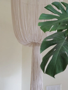 Detailed close-up of bohemian hand-woven cotton macrame lampshade with elegant tassel fringe