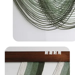 Close-up of green and white bohemian woven tapestry with natural wood hanging rod