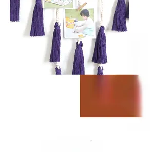 Detail of woven cotton rope photo holder with purple tassels for home wall decoration
