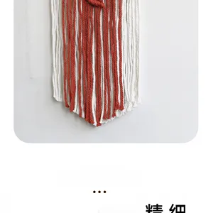 Detail of handmade macrame wall hanging with red and white cotton woven leaf tassels