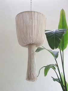 Close-up of bohemian hand-woven cotton macrame lampshade with long fringe details