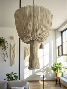 Detail of bohemian handmade cotton rope lampshade with long fringe in warm sunlight