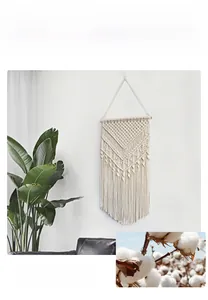 Macro detail of hand-woven cotton wall hanging with bohemian fringe and wooden pole