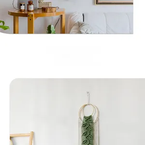 Close-up of handmade macrame wall hanging featuring green leaf patterns and cotton tassels