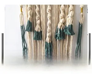 Detailed close-up of Bohemian hand-woven cotton tapestry with teal ombre dye and gold thread