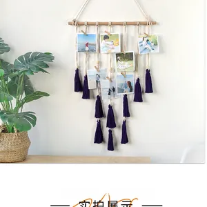 Detail of bohemian woven cotton rope photo hanger with purple tassels and wooden clips