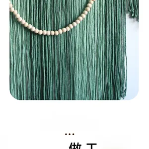 Detail of Nordic hand-woven green cotton tapestry with wooden beads and tassels