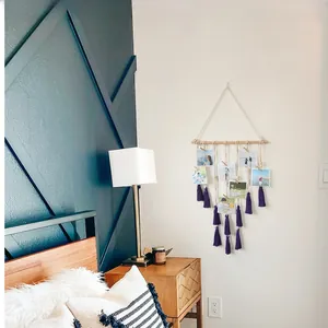 Detail of bohemian macrame photo hanging organizer with purple tassels and wooden clips