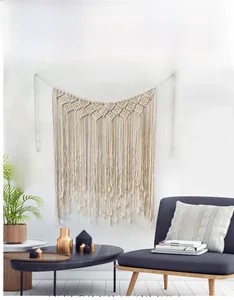 Detail of bohemian hand-woven macrame wall hanging with geometric patterns and long tassels