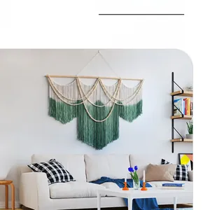 Close-up of handmade bohemian woven tapestry with gradient green fringe and wood beads