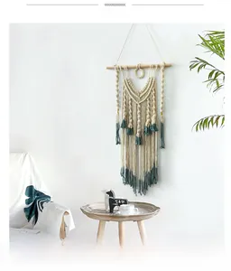 Detail of bohemian hand-woven tapestry with cream cotton ropes and dark green fringe