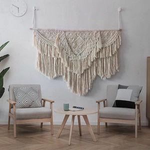Detail of bohemian macrame wall hanging featuring hand-woven geometric patterns and tassels