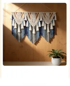 Détail d'une suspension murale macramé bohème avec dégradé bleu et franges sur bois
