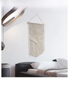 Detailed view of handmade macrame wall hanging with geometric weave and long fringe