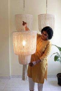 Detail of handmade boho macrame lampshade with cotton rope tassels and warm light glow