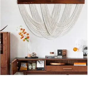 Detailed close-up of multilayered bohemian hand-woven cotton macrame wall hanging with fringe