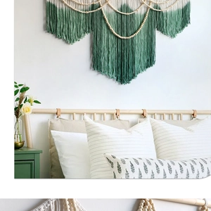 Detail of bohemian woven tapestry with green gradient cotton cords and wood beads