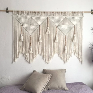 Detailed macro view of bohemian hand-woven macramé wall hanging with tassels and beads
