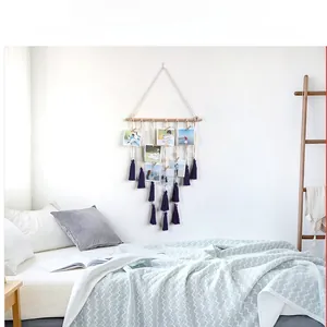 Detail view of woven cotton photo hanger with purple tassels and natural wooden clips