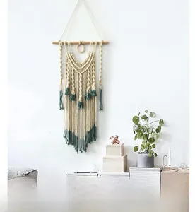 Close-up of handmade Bohemian woven wall tapestry with green fringe on wood rod