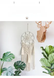 Detail of handmade macrame dream catcher with white cotton fringe and boho woven patterns