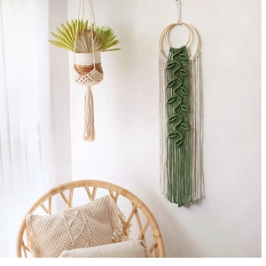 Detail of boho handwoven cotton macrame wall hanging with leaf patterns and tassels