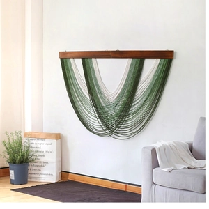 Detail of bohemian green and beige cotton tassel wall hanging on a wood rod