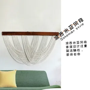 Detail of bohemian handmade macrame wall hanging with cotton fringe and wood bar