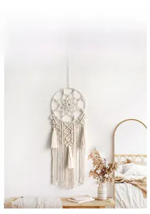 Detail view of Bohemian macrame wall hanging with intricate woven patterns and soft cotton fringe