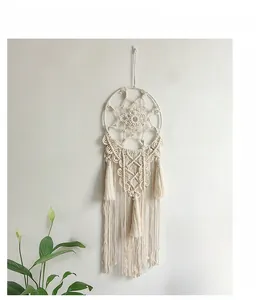 Detail of bohemian handmade woven wall hanging featuring geometric patterns and long tassels