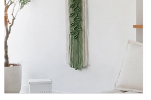 Detail of leaf-shaped woven wall hanging in emerald and beige cotton rope for boho decor
