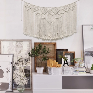 Macro detail of bohemian macramé wall hanging with geometric weave and cotton fringe