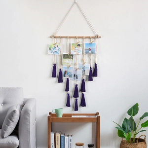 Boho woven cotton photo display hanger with wood rod and deep purple tassels on white wall