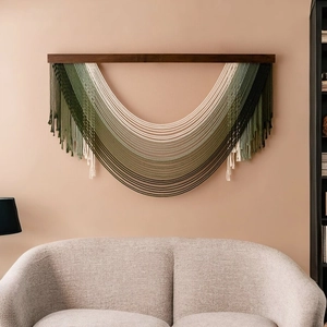 Large bohemian macrame wall hanging with green gradient layers on a wooden rod
