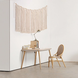 Macro detail of Bohemian hand-woven cotton wall hanging featuring geometric patterns and tassels