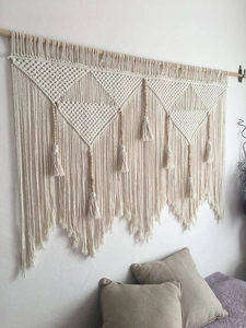 Macro detail of handmade macrame wall hanging with geometric weave and wood beads
