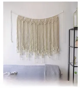Detail of bohemian macramé wall hanging with geometric patterns and long fringes