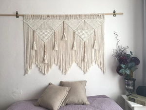 Detailed close-up of handmade Bohemian macrame wall hanging with wooden beads and fringes