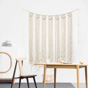Detailed view of handmade boho wall hanging with woven macrame knots and long tassels