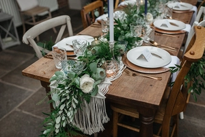 Detailed close-up of bohemian hand-woven cotton table runner with fringe and geometric knots