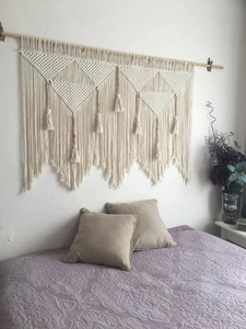 Detailed macro view of bohemian hand-woven tapestry with geometric patterns and wooden beads
