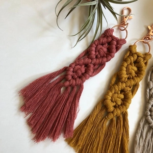 Detail view of handmade macrame tassel keychains in multiple colors with lobster clasps