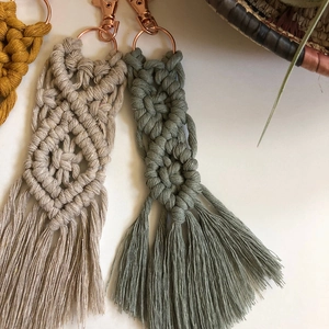 Close-up of bohemian hand-woven cotton macrame keychain with elegant rose gold metal clasp