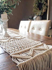 Detail of macrame table runner with hand-woven geometric patterns and long tassels